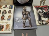 several books on display on a table with a clock in the background