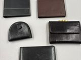quatre modèles différents de portefeuilles en cuir posés sur un fond blanc