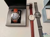 two watches and a watch box on a table