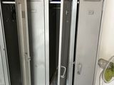 several metal lockers are stacked up in a room with a fan