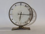une horloge posée sur un support sur une table