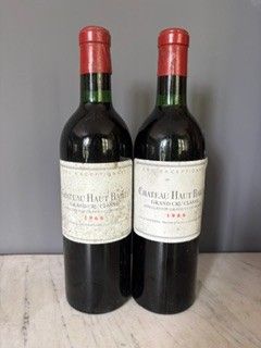 two bottles of wine sitting on top of a table next to each other