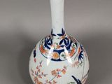 a white vase with a blue and orange design on it