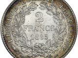 a silver coin with a wreath of leaves on it