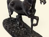 statue d'un cheval noir sur un socle noir, sur fond blanc