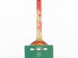 a red and white vase with a green label on it