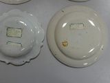 three white plates with different designs on them sitting on a table