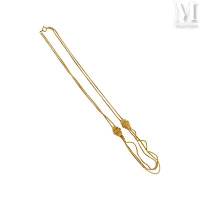 gros plan d'un collier en or sur fond blanc