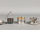 quatre tasses et cuillères en argent sont alignées sur une table
