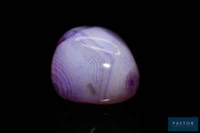 une photo d'une pierre violette posée sur une surface noire