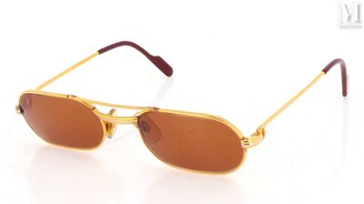 lunettes de soleil dorées aux verres marron sur fond blanc