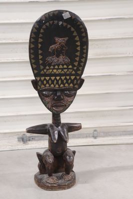 a wooden sculpture of a man and a dog on a stand