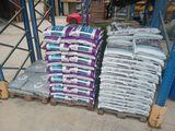 many bags of cement sitting on pallets in a warehouse
