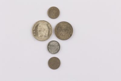 several different coins are arranged in a row on a white surface