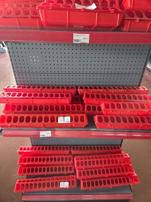 a display case filled with lots of red bins in a store