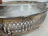 a glass bowl with a metal handle on a table