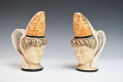 une paire de figurines en céramique représentant un homme et une femme coiffés de chapeaux
