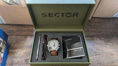 une boîte contenant une montre et un stylo, posée sur une table