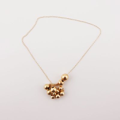 a gold teddy bear necklace on a gold chain