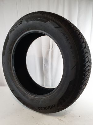 tire on a white surface with a white curtain in the background