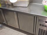 stainless steel counter top in a commercial kitchen with two bowls of food on it