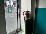 a fire extinguisor in the corner of a room next to a window