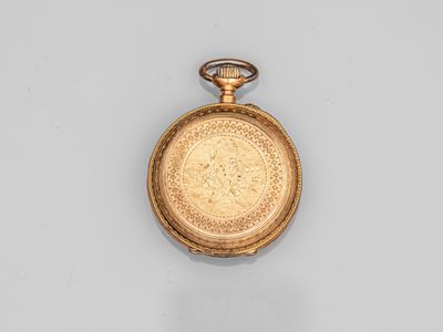 une vieille montre de poche en or avec une chaîne, posée sur une surface blanche