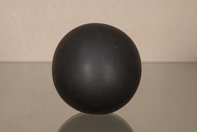 une boule noire posée sur une table en verre