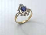 a close up of a gold ring with a sapphire and diamonds