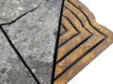 un gros plan sur un morceau de pierre sur lequel figure un triangle
