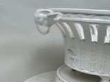 a white vase sitting on top of a white plate