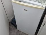 un petit réfrigérateur et un lave-vaisselle dans un coin de la pièce