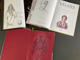 three books with drawings of a woman and a man sitting on top of a table