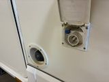 an electrical outlet on the side of a white refrigerator