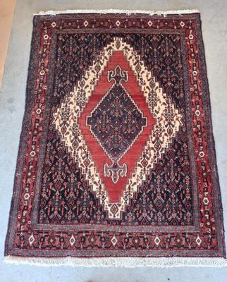 un tapis oriental à motifs de losanges posé sur un sol gris