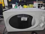 un micro-ondes blanc posé sur une table, avec une étiquette de prix dessus