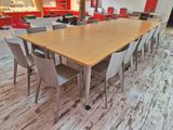 tables and chairs in a room with red walls and wood flooring
