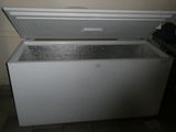 a white chest freezer sitting in the corner of a kitchen