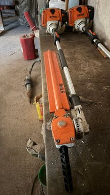 deux tronçonneuses posées sur un banc dans un garage