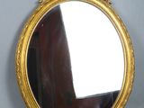 an image of a gold framed mirror sitting on top of a table