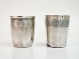 two silver cups sitting next to each other on a table
