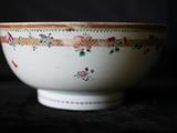 un bol blanc orné de fleurs, posé sur une table