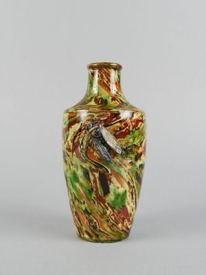 a vase with a bird on it sitting on a table