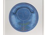 tableau encadré représentant le dessin d'un enfant : un visage souriant sur une assiette bleue