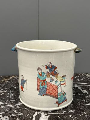 a white bucket with a painting on it sitting on a table