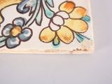 a picture of a ceramic tile with flowers on it