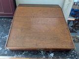 a small wooden table with a marble top on the floor