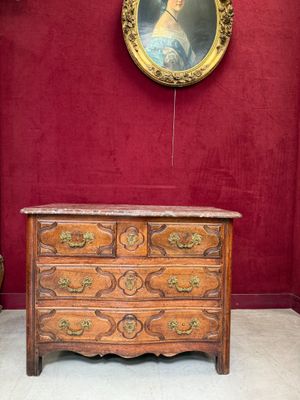 une commode en bois dans une pièce où est accroché un tableau au mur