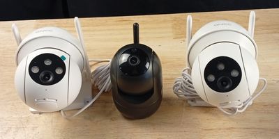 three cameras are sitting on a table with wires attached to them