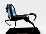 statue d'un cheval noir sur un socle noir, sur fond blanc